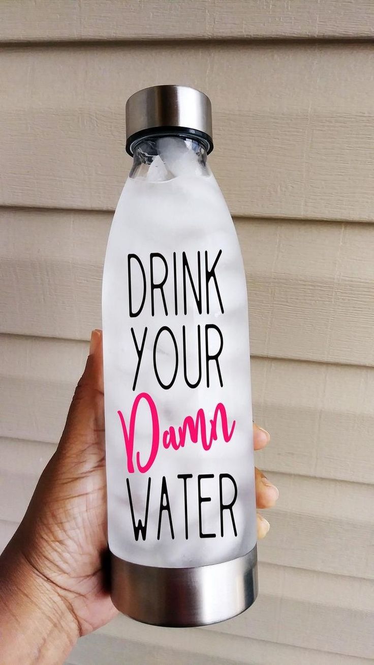 a person holding up a water bottle with the words drink your damn water on it