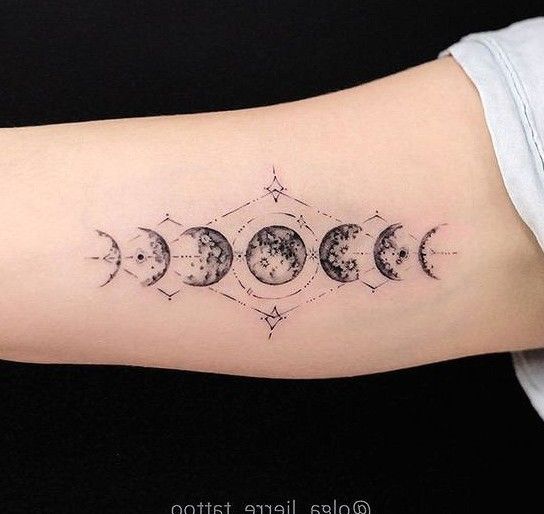 a woman's arm with phases of the moon and stars tattoo design on it