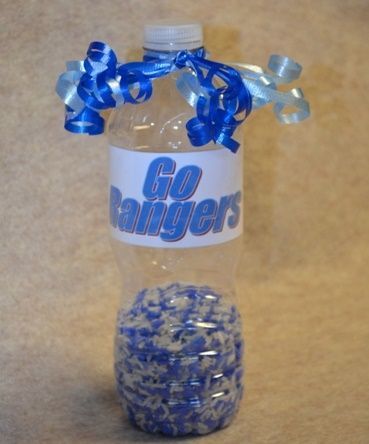 a bottle with blue and white confetti in it sitting on the floor next to a ball