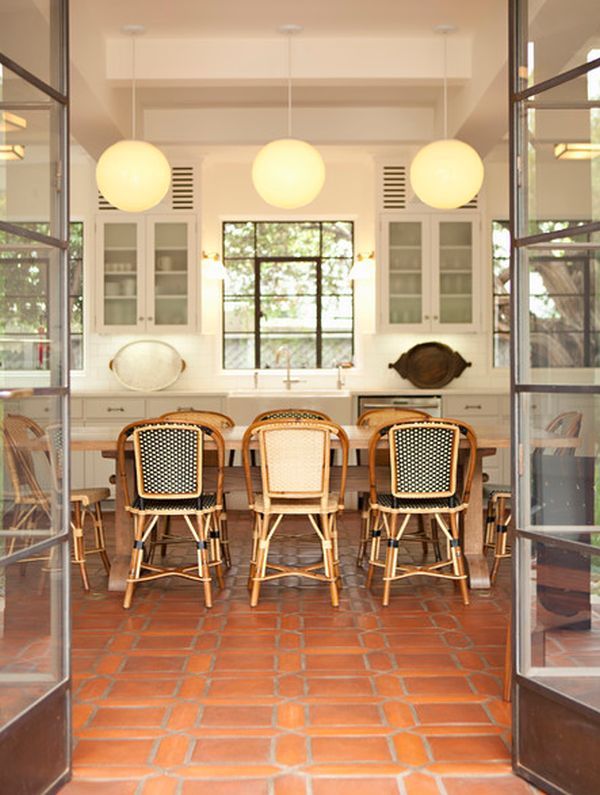 a dining room table and chairs in front of an open glass door that leads to the kitchen