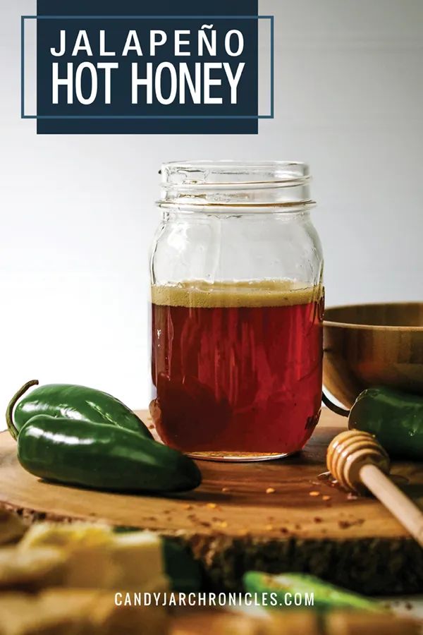 jalapeno hot honey in a glass jar next to green peppers