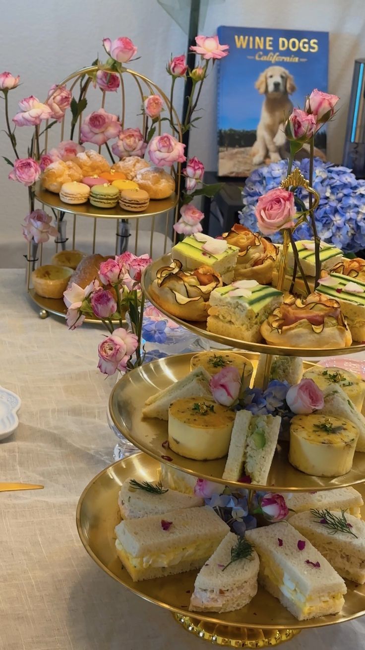 three tiered trays filled with different types of desserts and pastries on top of a table