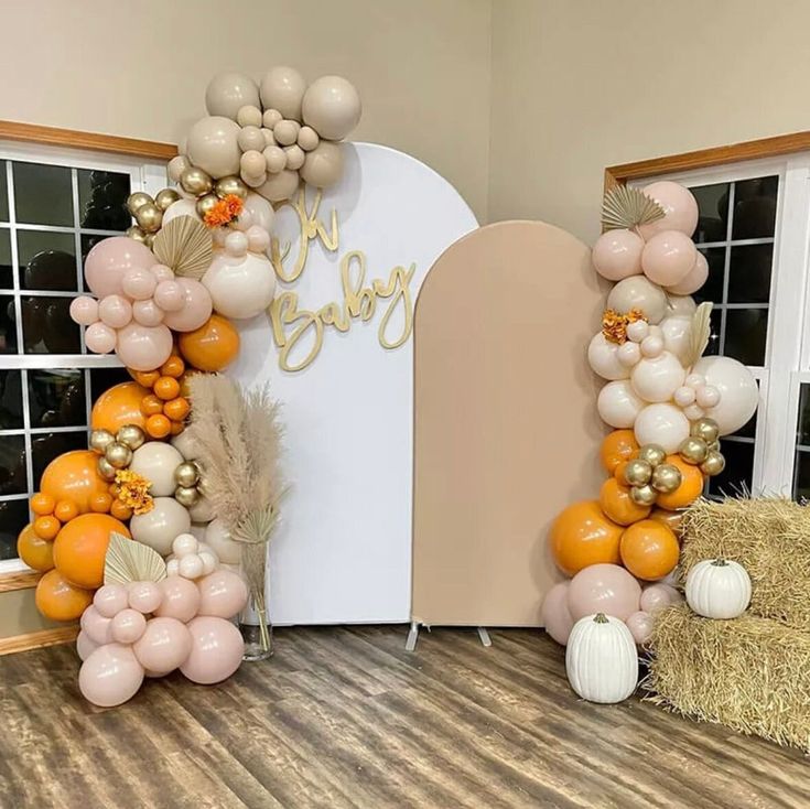 an arch made out of balloons and some hay