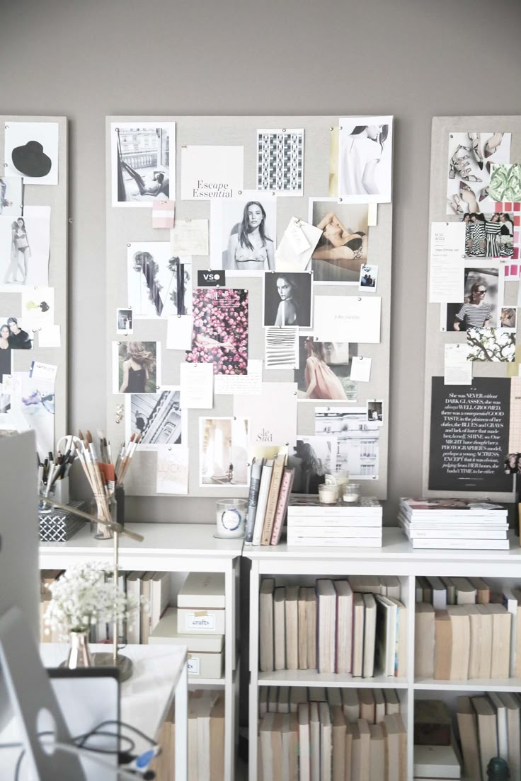 a desk with many books and pictures on the wall