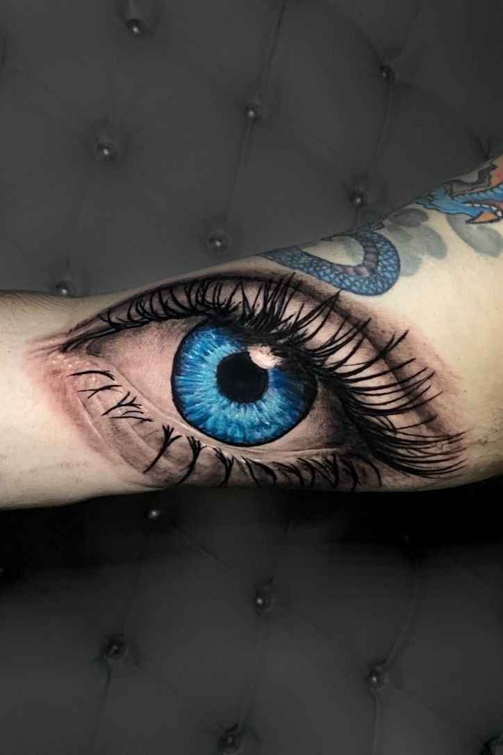 an arm with a blue eye and dragon on it