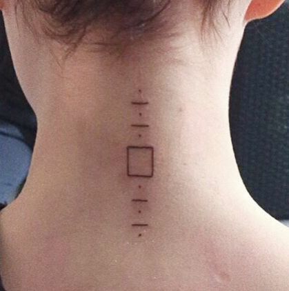 the back of a woman's neck has a small tattoo on it that reads,