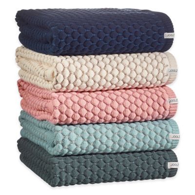 four towels stacked on top of each other in different colors and patterns, all folded together