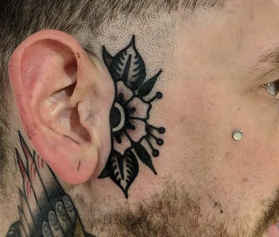 a man with a tattoo on his face and ear