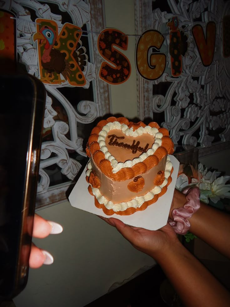 a heart shaped cake being held by someone