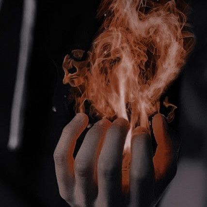 a person holding out their hand with some fire in the middle of it's fingers