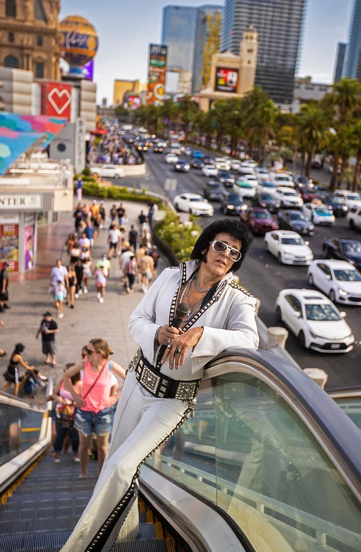 a man standing on top of an escalator next to a crowd of people