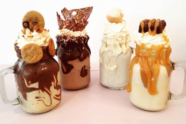 there are four desserts in mason jars with ice cream and caramel on top