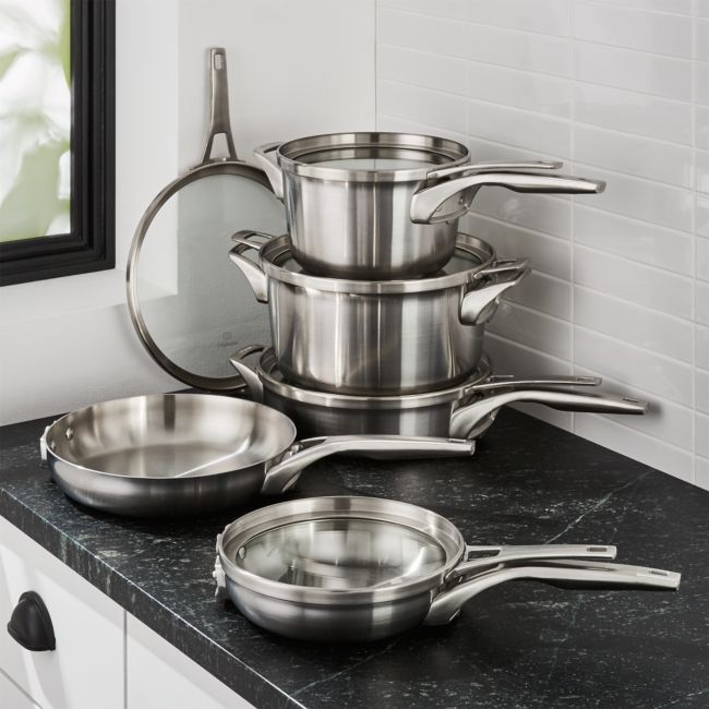 stainless steel pots and pans sit on a counter