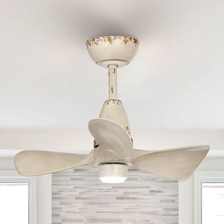 a white ceiling fan in a room with tile walls and flooring on the wall