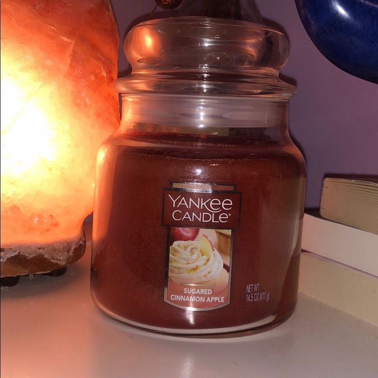 a candle sitting on top of a table next to a book and an orange light