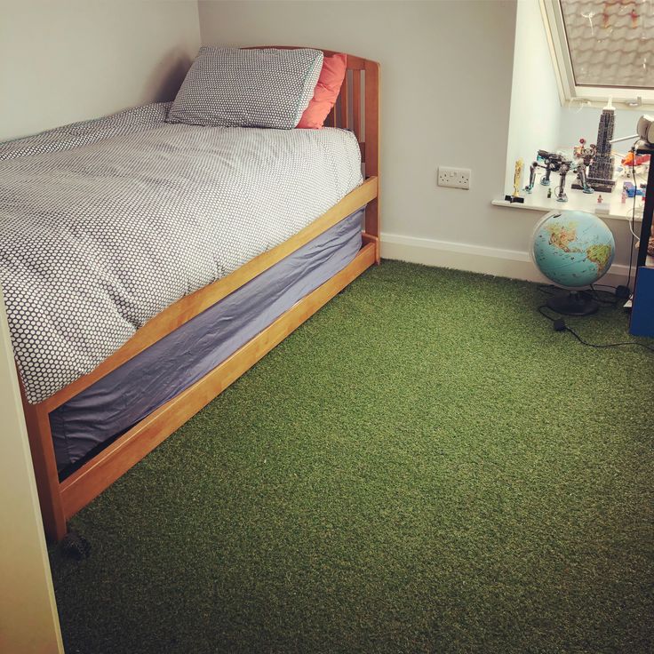 a bedroom with a bed and green carpet