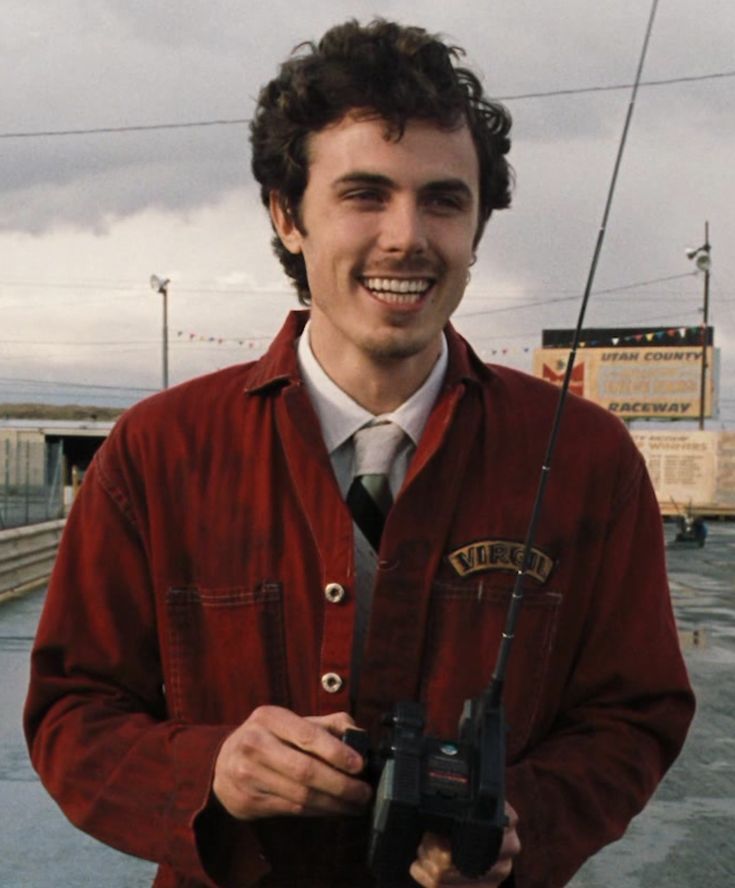 a man in a red jacket is holding a radio