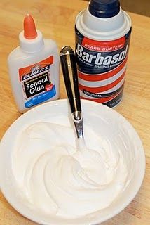 a white plate topped with whipped cream next to a bottle of glue and a pen