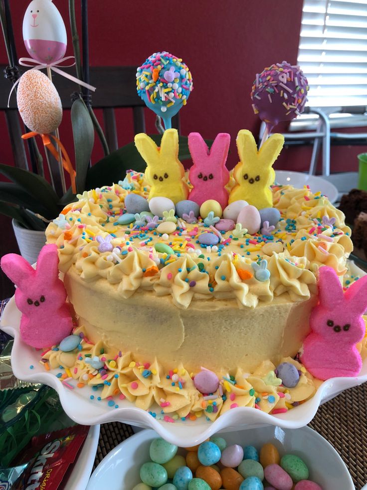 a cake decorated with peep holes and candies on a table next to other desserts