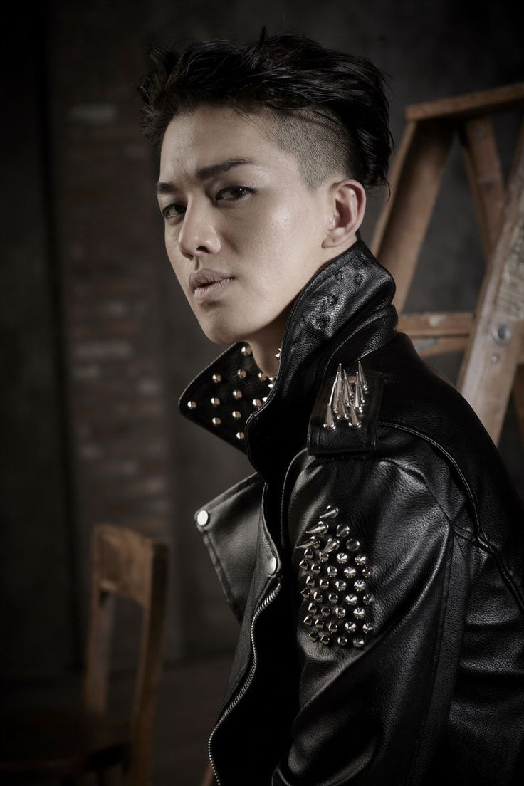 a man with spiked hair wearing a black leather jacket and studded collared shirt