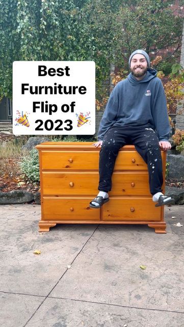 a man sitting on top of a wooden dresser next to a sign that says best furniture flip of 2013