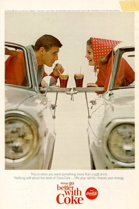 two people sitting in the back of a car eating food and drinking beverages from cups