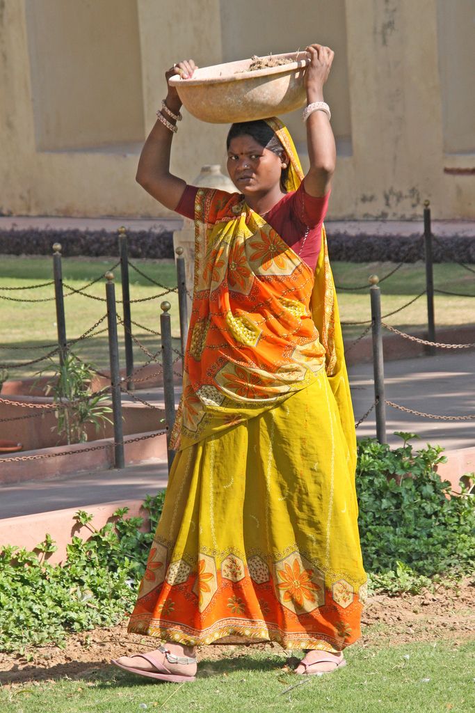 a woman carrying a bowl on her head