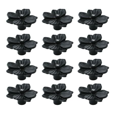 twelve black plastic flowers on a white background