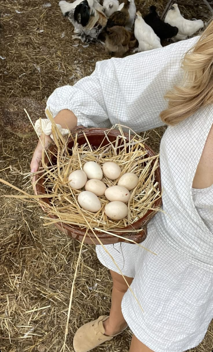 a woman holding a basket full of eggs