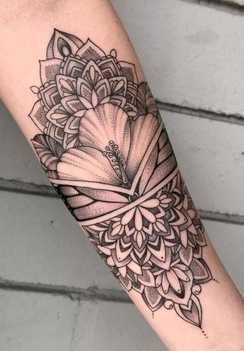 a black and white flower tattoo on the arm