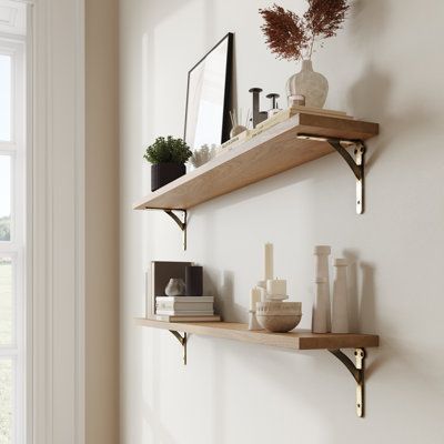 two wooden shelves on the wall with vases and other items in front of them