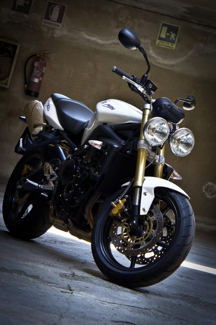 a white and black motorcycle parked in a garage