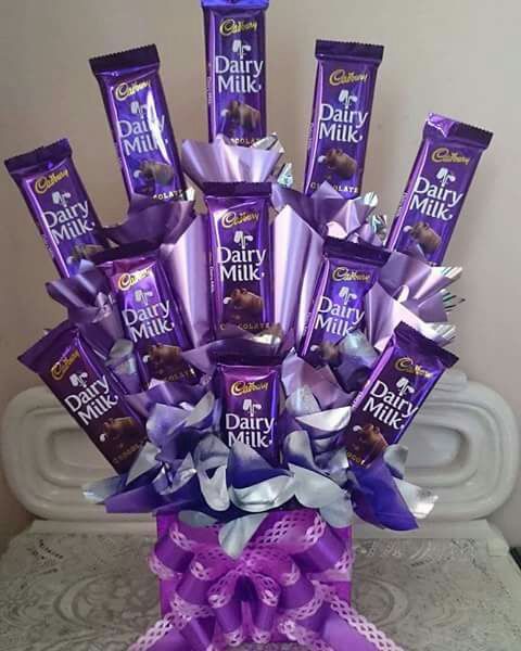 a purple vase filled with chocolates on top of a table