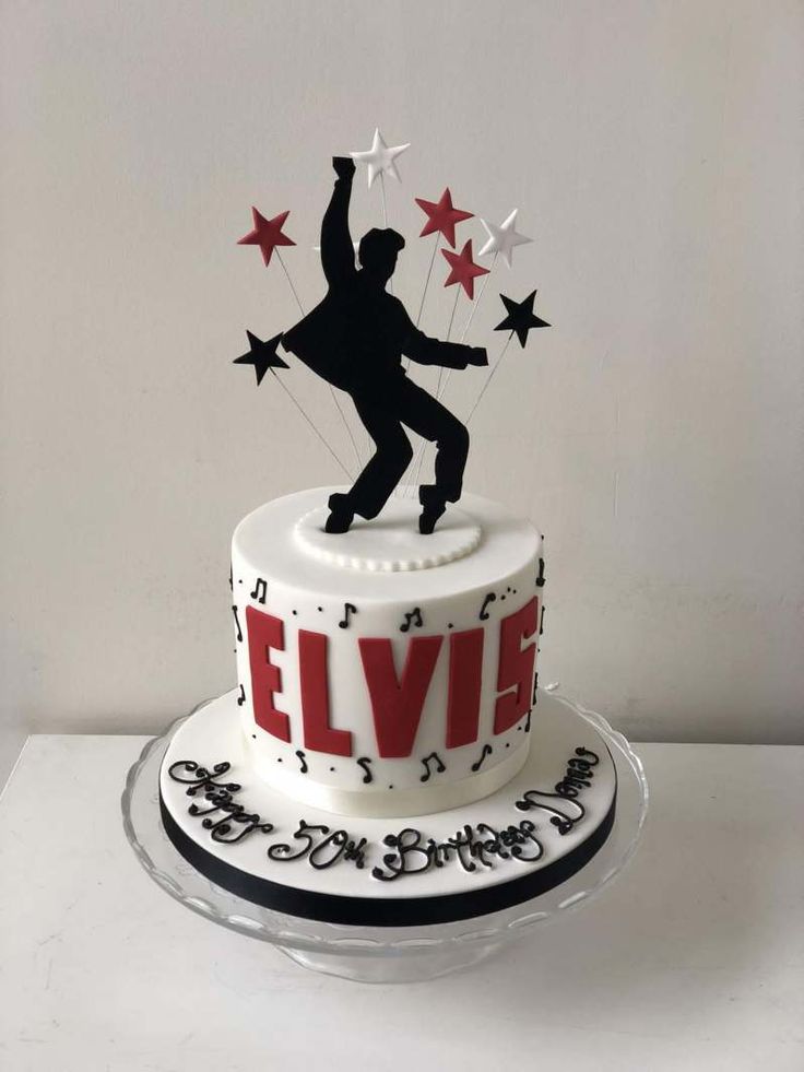 a white cake with black and red decorations on it that says elvis in the middle