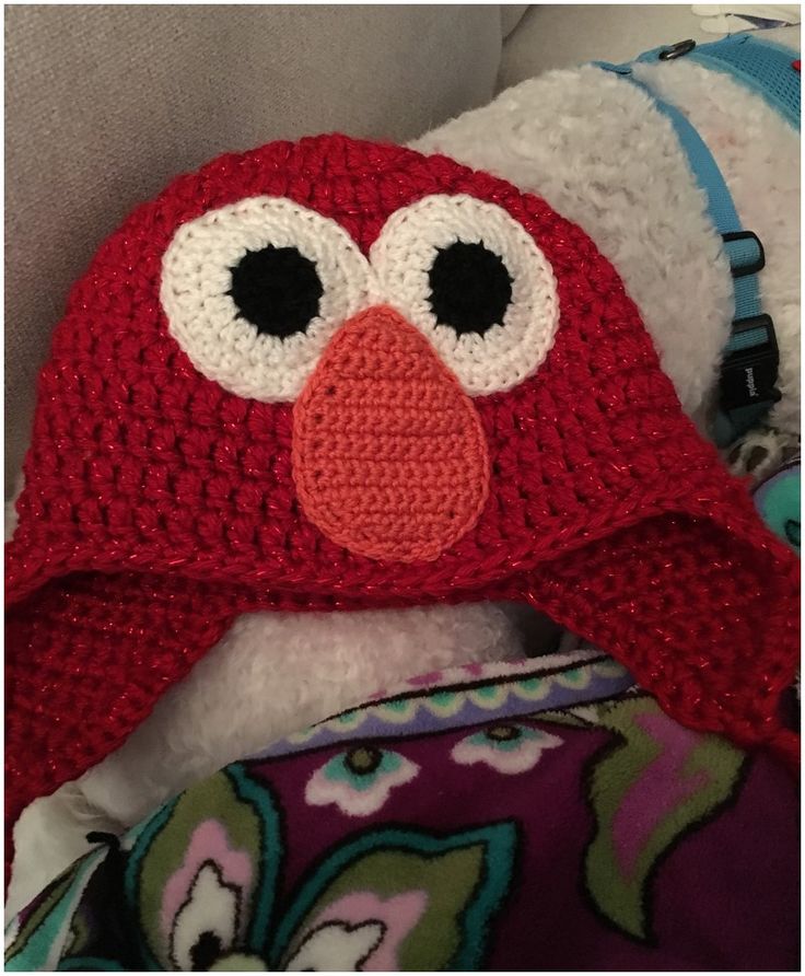 a crocheted red bird hat with big eyes