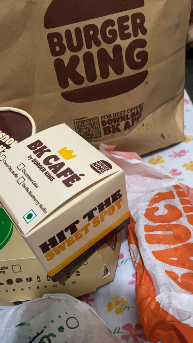 a burger king box sitting on top of a table next to a brown paper bag