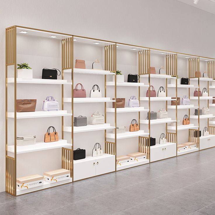 a row of shelves with purses and handbags on them in front of a white wall