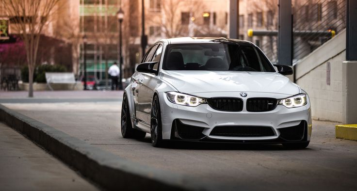 a white car is parked on the street