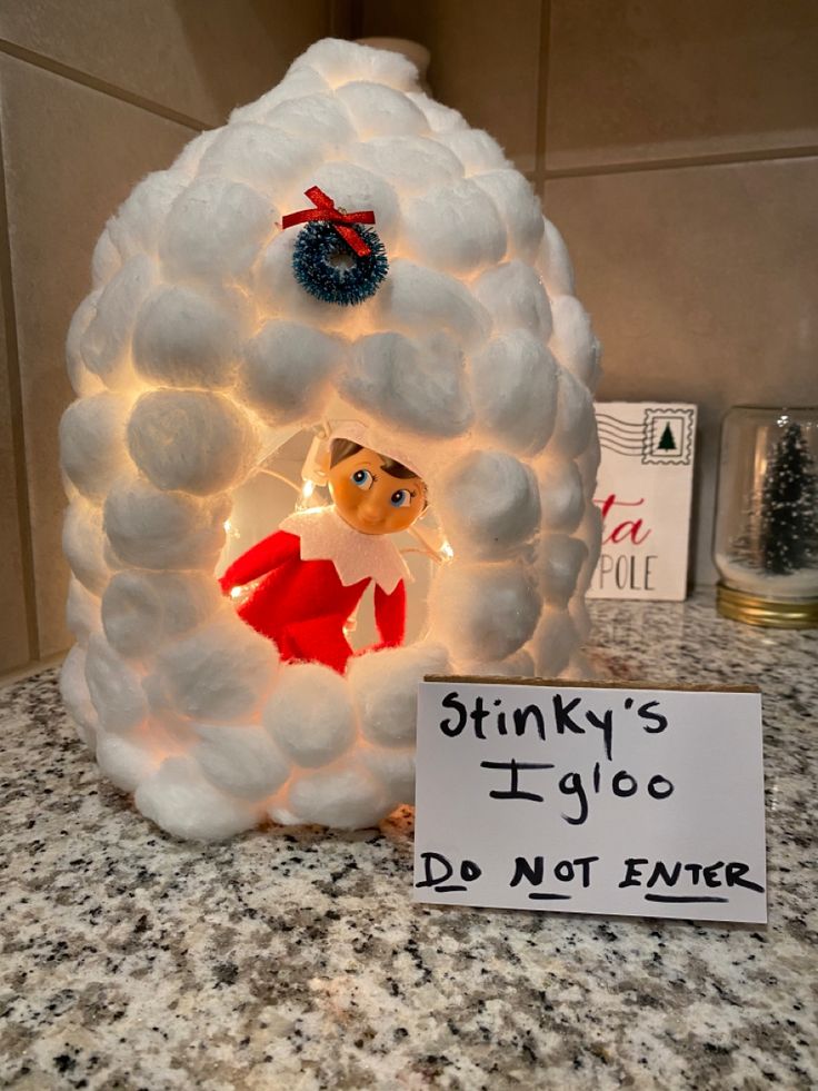 a light up snowman in the middle of a kitchen counter with a sign that says stinky's ugly do not enter