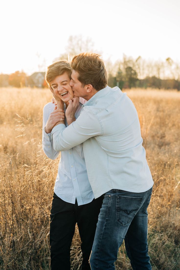 two men hugging each other in the middle of a field