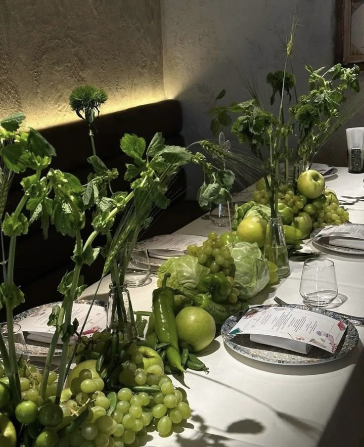 a long table is set with grapes and green vegetables