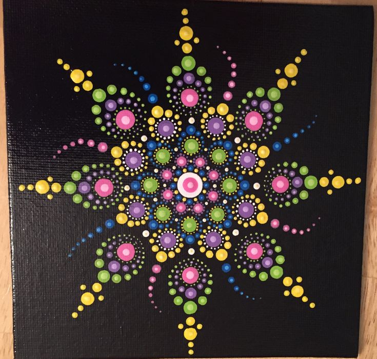 a painting on a black board with colorful dots and circles in the center, as well as an eye