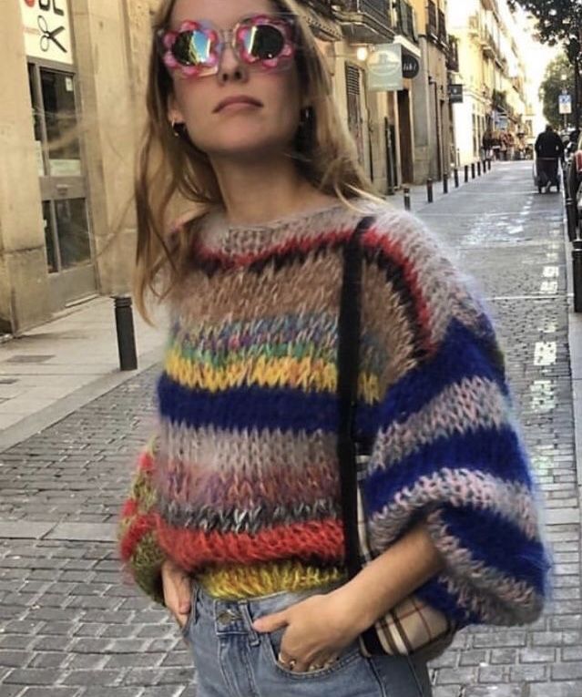 a woman wearing sunglasses and a colorful sweater