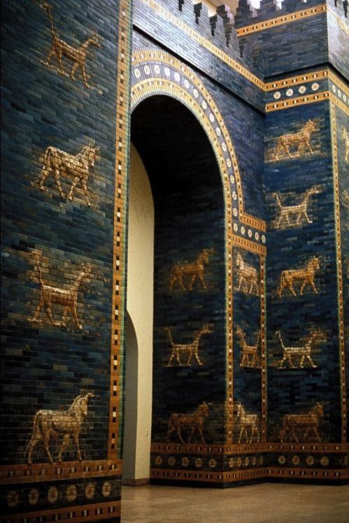 an arch with paintings on the side of it in front of a wall that has horses and chariots painted on it