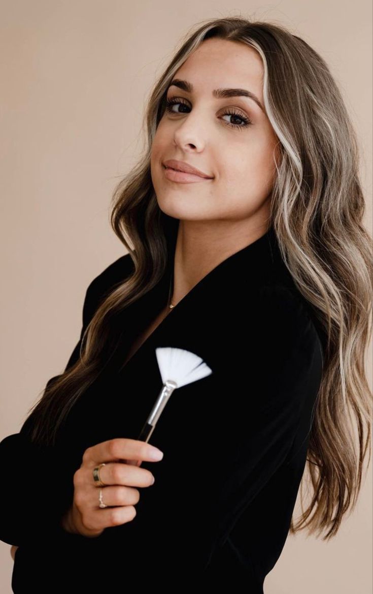 a woman with long hair wearing a black top and holding a golf club in her hand