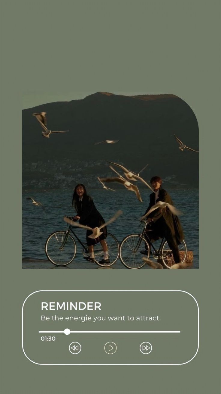 two people riding bikes on the beach with seagulls flying around and behind them