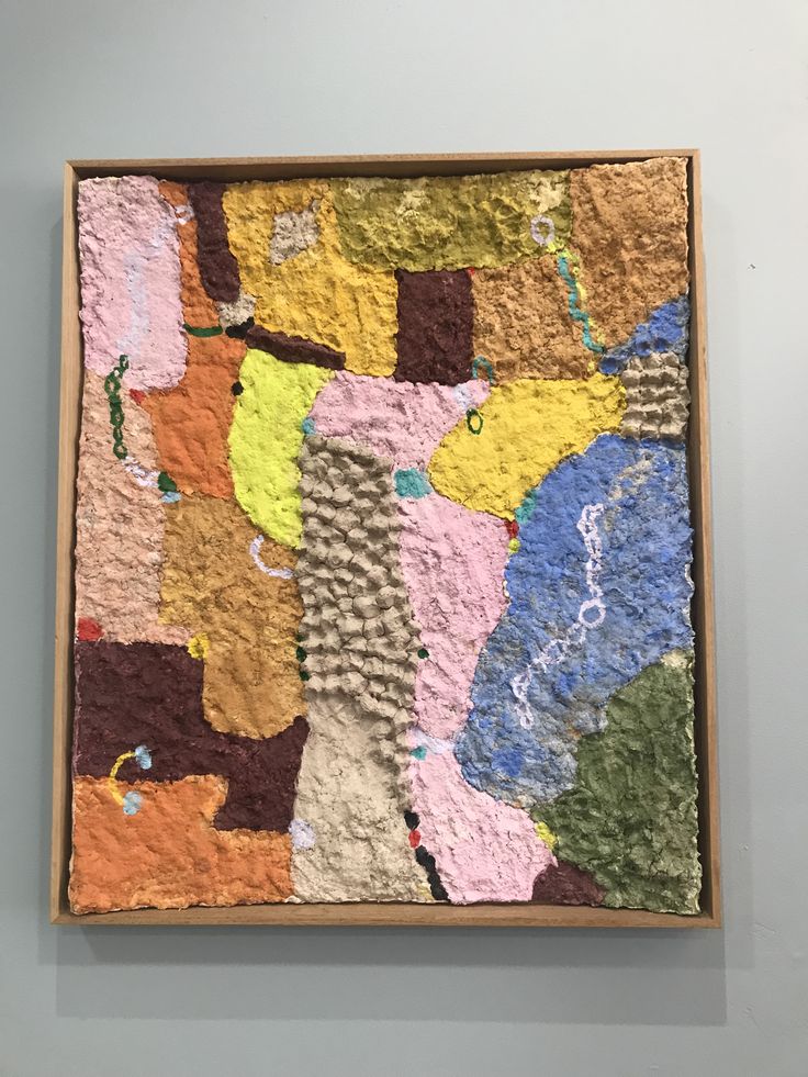 an abstract painting on display in a wooden frame