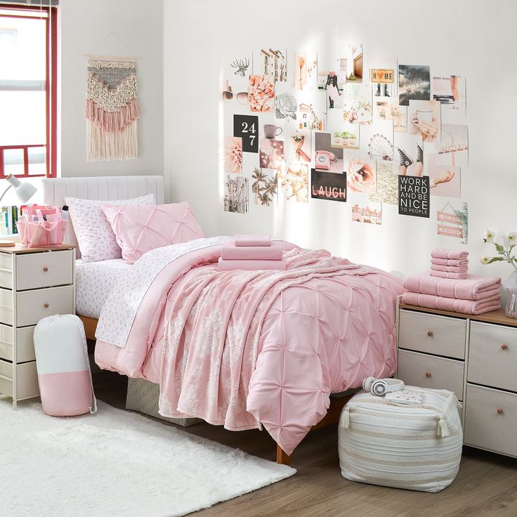 a bedroom with pink bedding and pictures on the wall