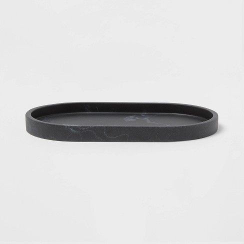 an empty black plastic plate on a white surface