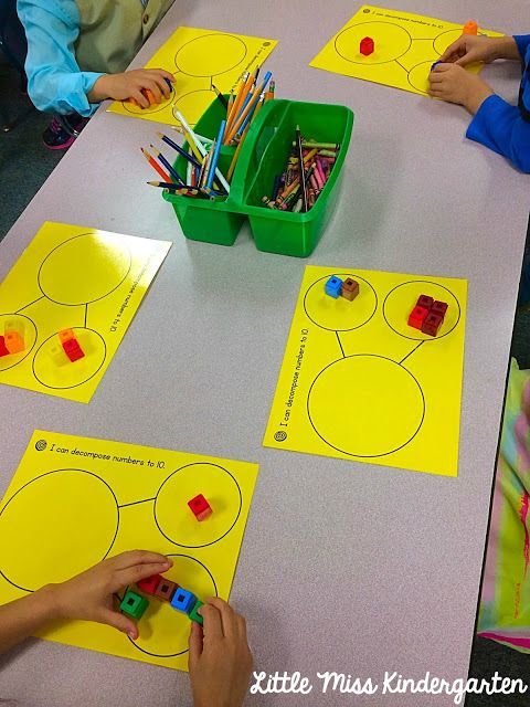 several children are sitting at a table with yellow paper and colored pencils on them